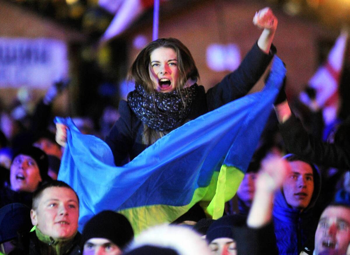 A woman shouts slogans and holds a Ukrainian flag during an opposition rally at Independence Square in Kiev.