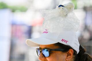 An attendee with a bag of ice on their head during high temperatures at the Great American State Fair in Washington on July 4. Photographer: Pete Kiehart/Bloomberg