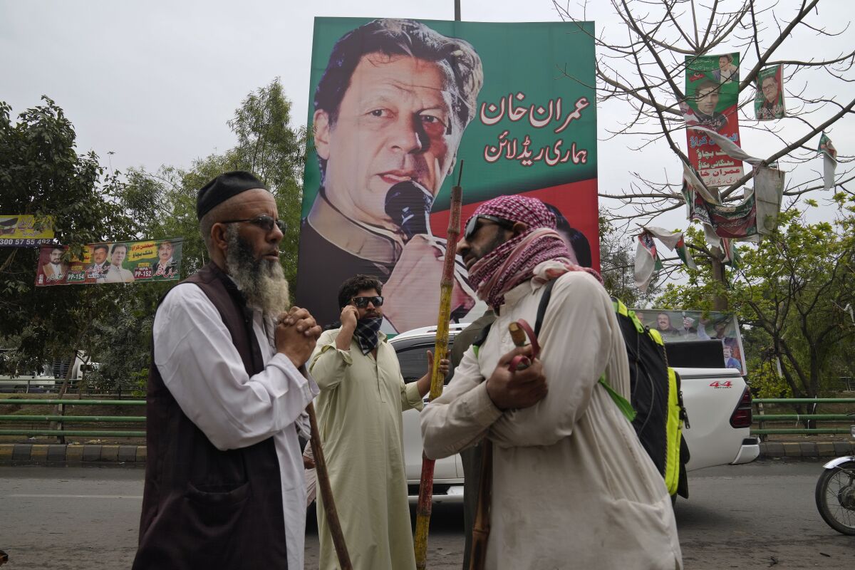 Supporters of former Pakistani Prime Minister Imran Khan holding sticks
