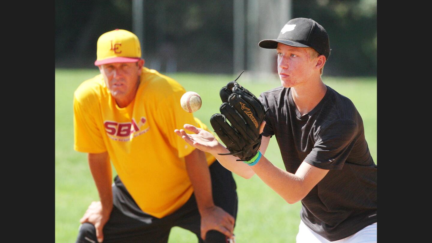 Matthew Hardy, 12, of La Cañada, catches a toss to him at second base under the watchful attention of La Cañada baseball coach Matt Whisenant at the Spartan Baseball Academy at La Cañada High School on Monday, July 31, 2017. About 20 campers participated in different drills, mostly under the watchful attention of La Cañada baseball coach Matt Whisenant, formerly a Major League Baseball pitcher, and a graduate of La Cañada High School in 1989.