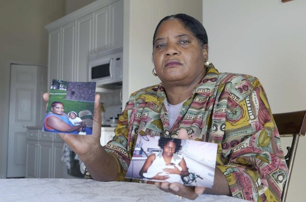 Helen Brown holds a photo of grandson Thierry LaMarque Jr., left, and one of his mother, Glenda Brown.