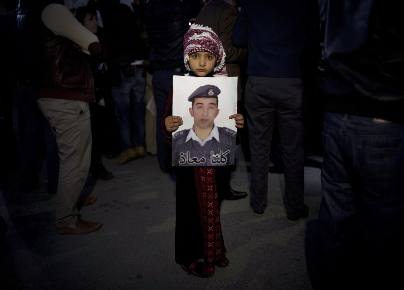A Jordanian child holds a poster of pilot Lt. Moaz Kasasbeh, who was captured by Islamic State militants in Syria and has reportedly been killed.