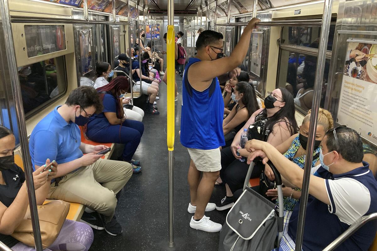 Varias personas usan la mascarilla contra el COVID en el tren subterráneo de Nueva York