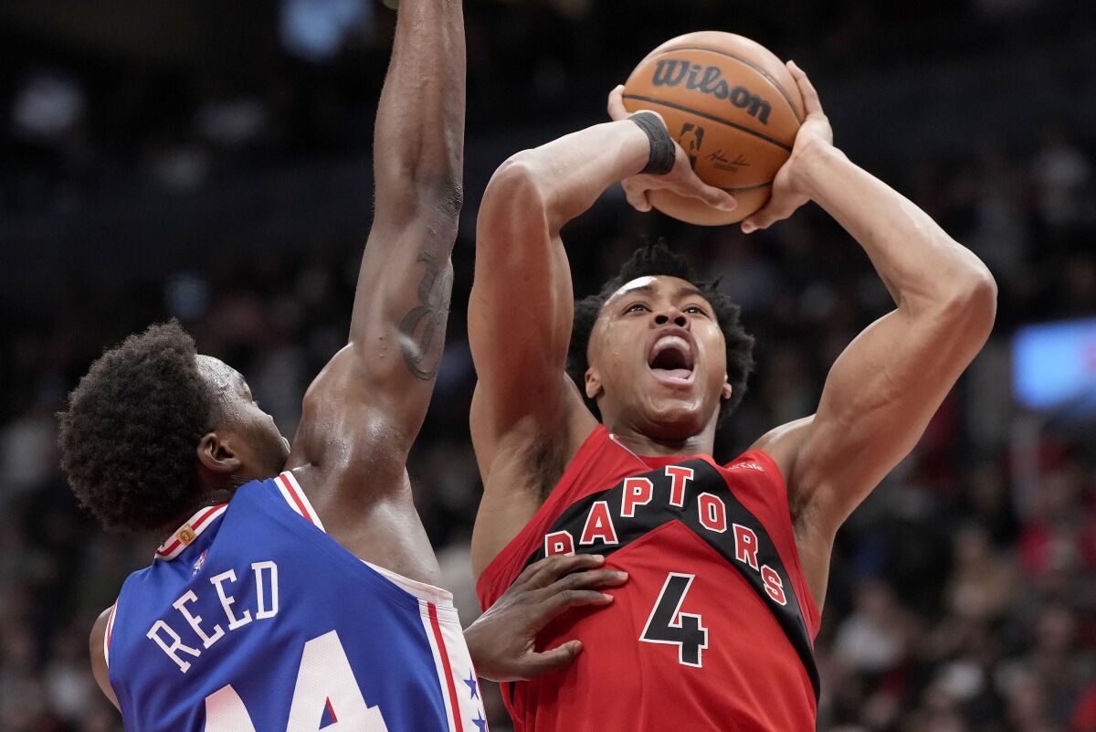 Toronto Raptors forward Scottie Barnes (4) is defended by Philadelphia 76ers forward Paul Reed (44) during the first half of an NBA basketball game Thursday, April 7, 2022, in Toronto. (Frank Gunn/The Canadian Press via AP)