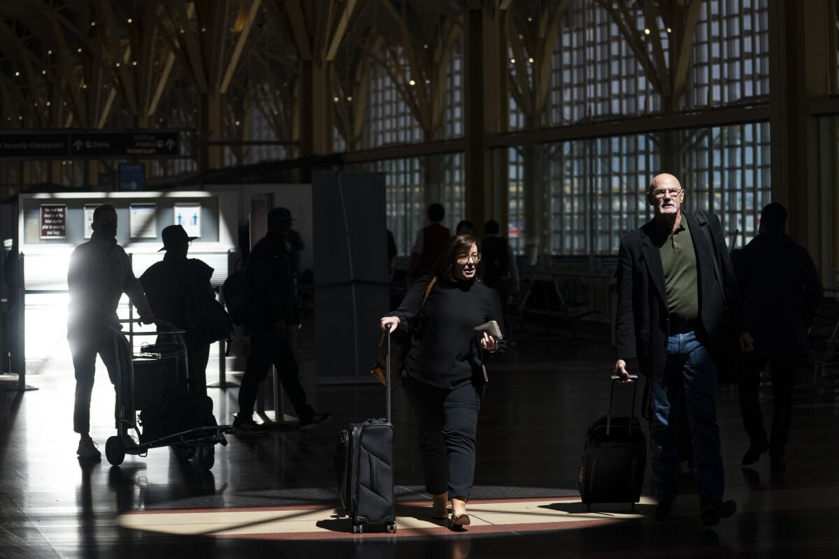Passengers walk through an airport terminal