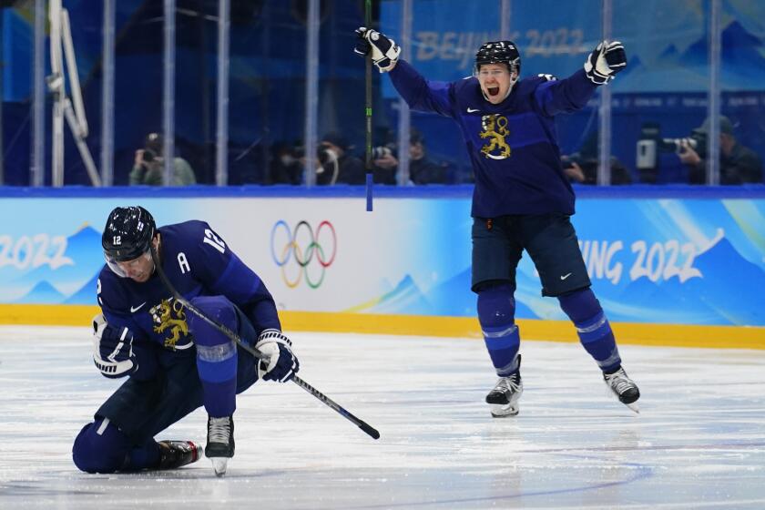 Finland's Marko Anttila (12) and Ville Pokka (2) celebrate a goal by teammate Hannes Bjorninen.