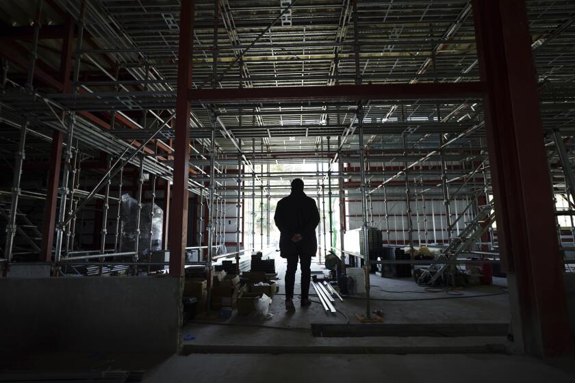 Michihiro Kono, president of Yagisawa Shoten Co., stands at a his factory under construction Friday, March 5, 2021, in Rikuzentakata, Iwate Prefecture, northern Japan. Just a month after a tsunami as high as 17 meters (55 feet) smashed into the city of Rikuzentakata, soy sauce maker Kono inherited his family's two-century-old business from his father. Later this year the ninth generation owner of Yagisawa Shoten Co. will open a new factory on the same ground where his family started making soy sauce in 1807. (AP Photo/Eugene Hoshiko)