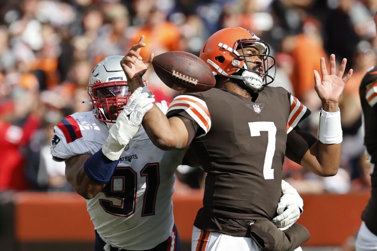 New England Patriots defensive end Deatrich Wise Jr., left, snatches the ball from Cleveland's Jacoby Brissett.
