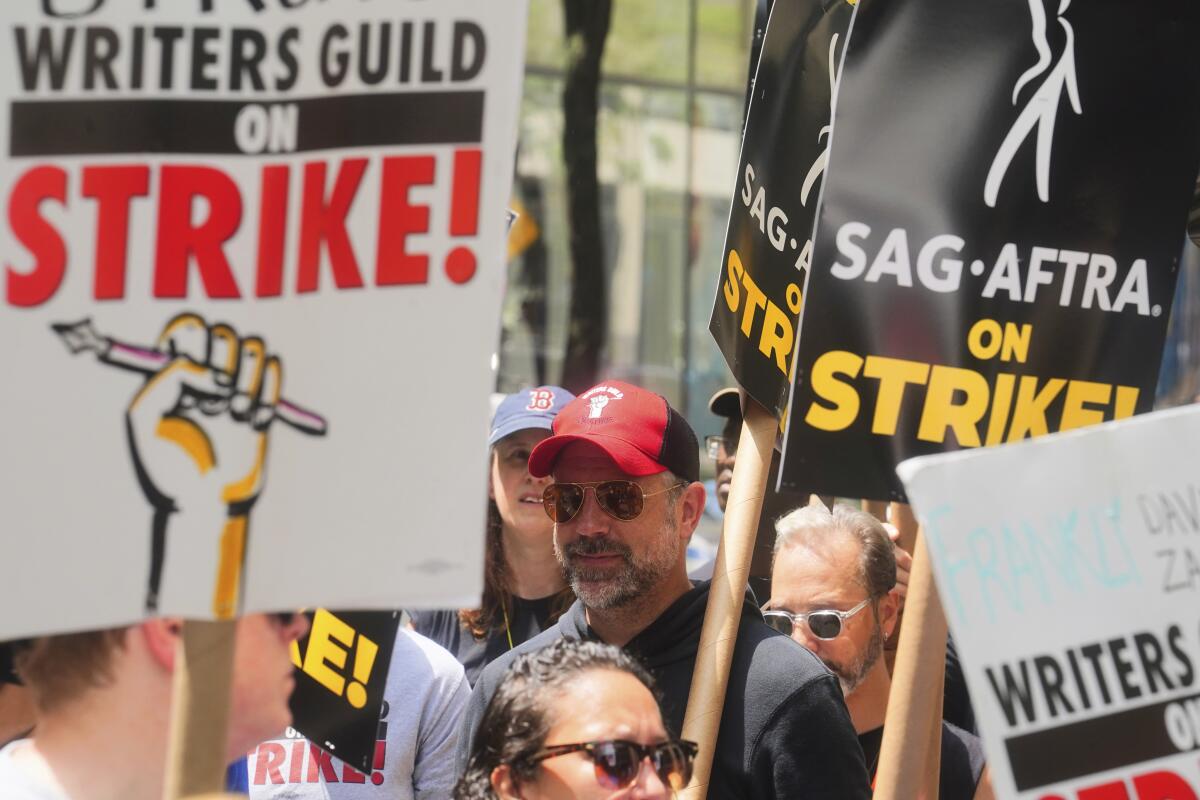 Actor Jason Sudeikis, center, walks a picket line with striking writers and actors in New York on July 14.