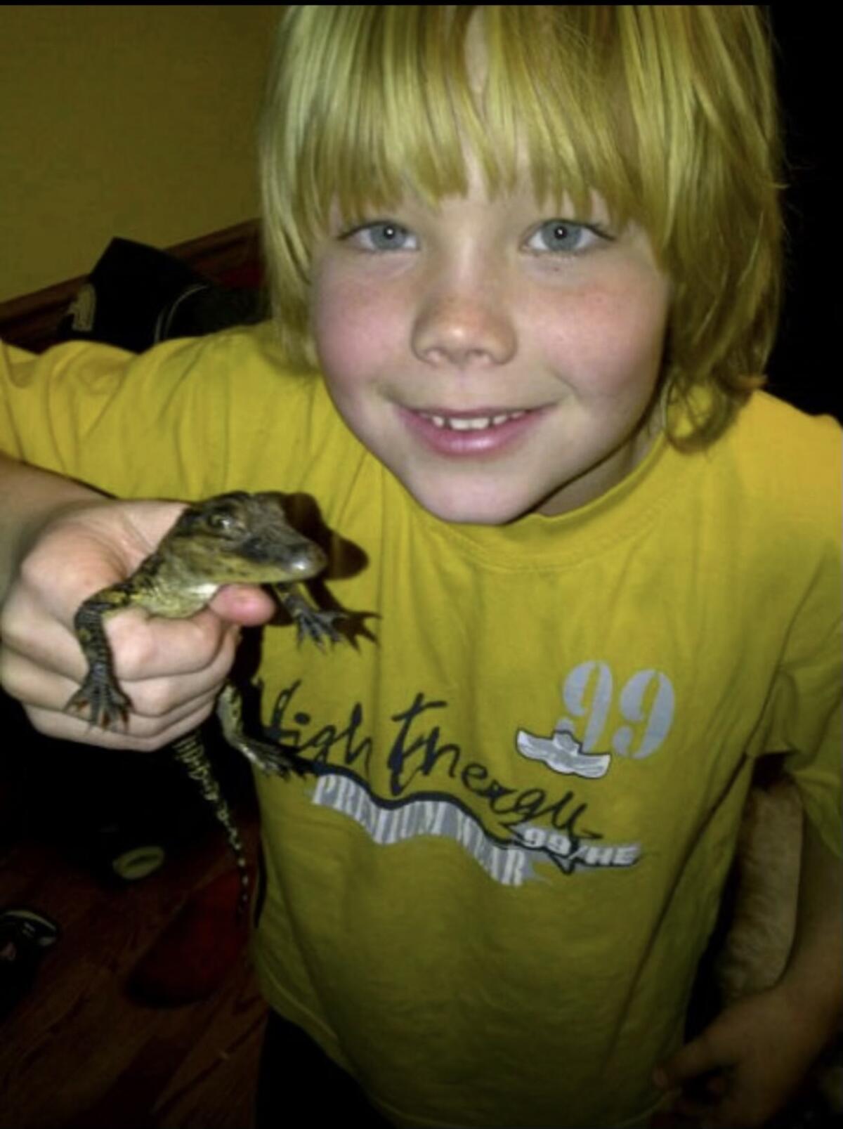 Carson Steele holds a tiny Crocky-J after first receiving the alligator "from Santa Claus" about 10 years ago.