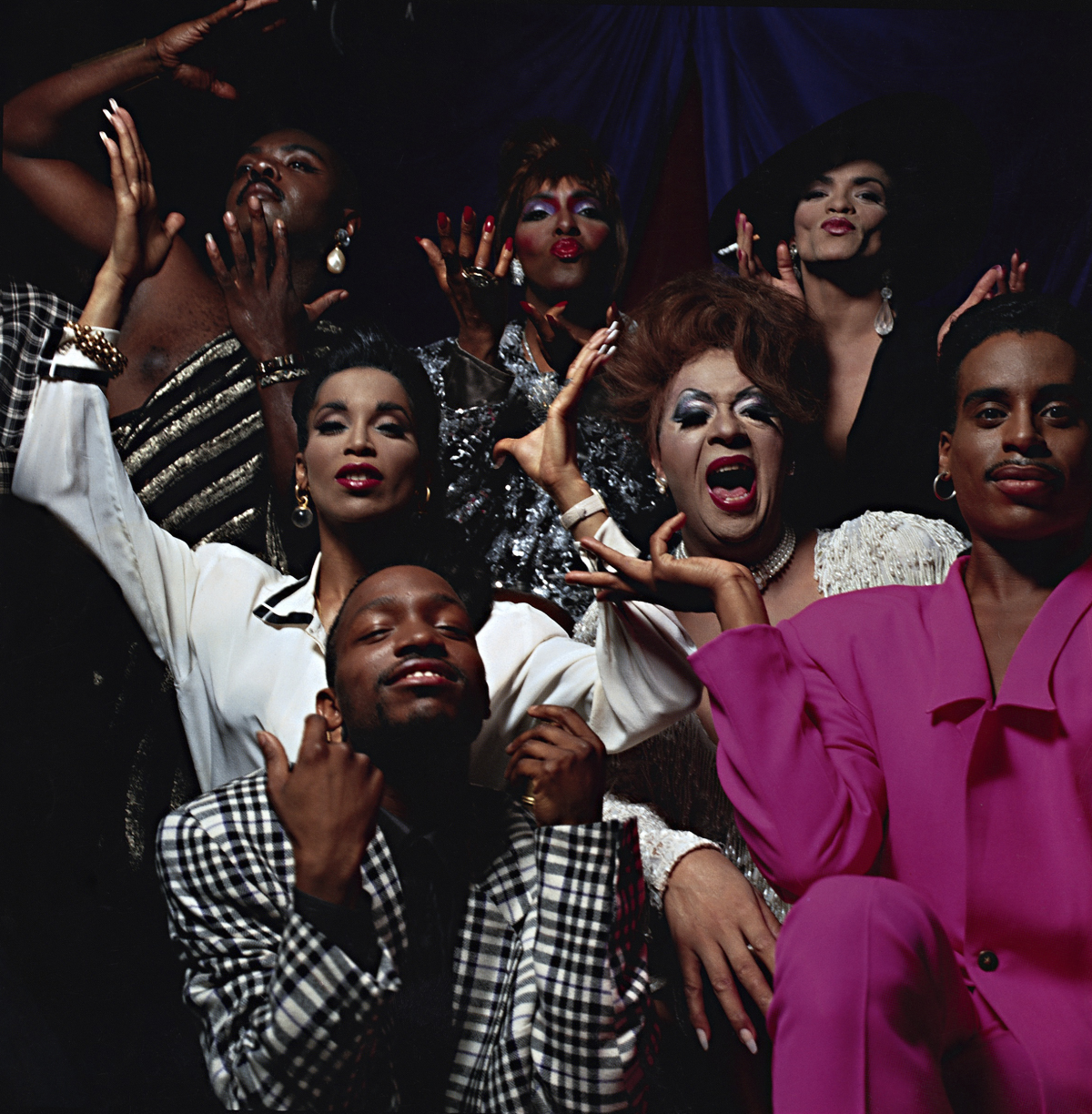 Drag queens and dancers pose for a loving camera.