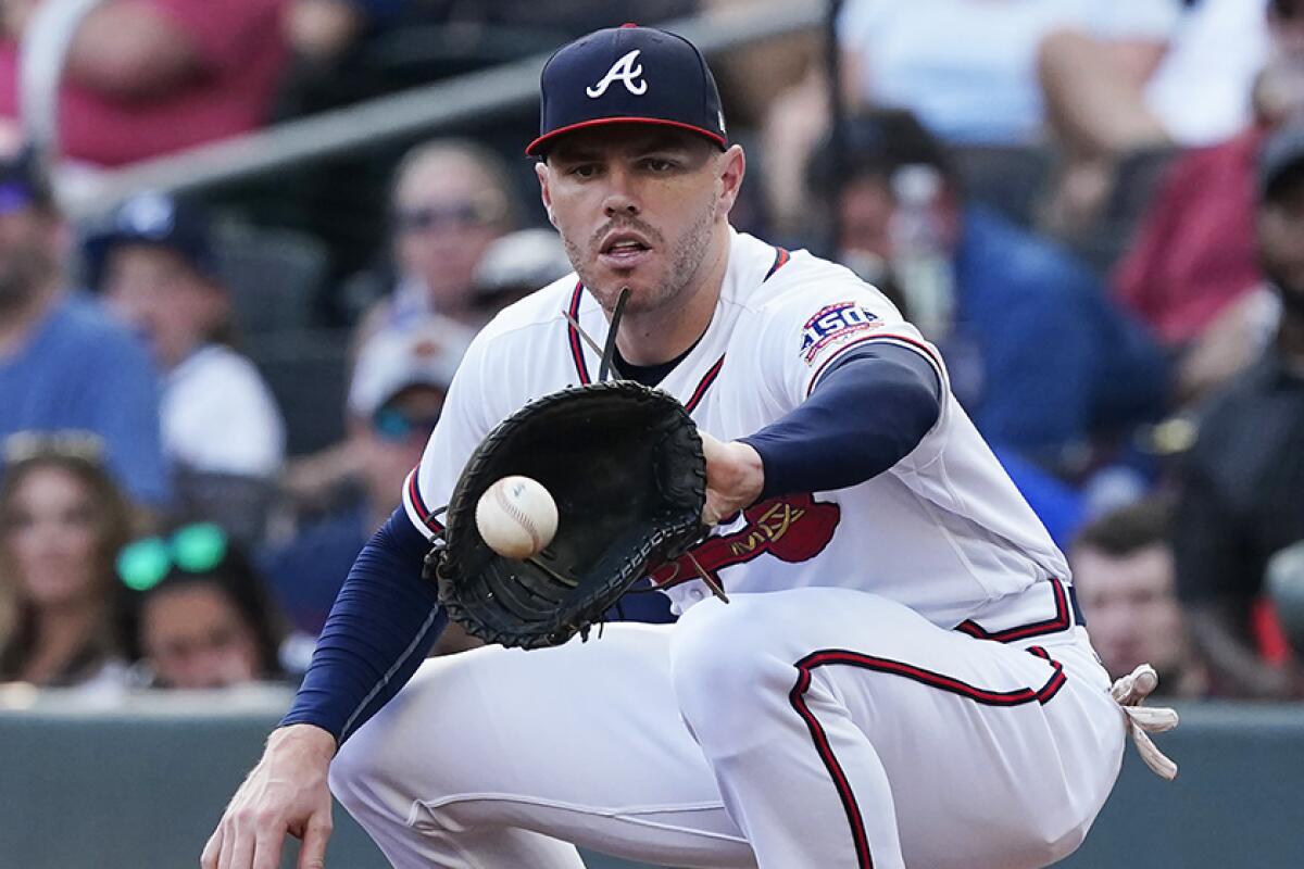 First baseman Freddie Freeman squats to catch a thrown ball