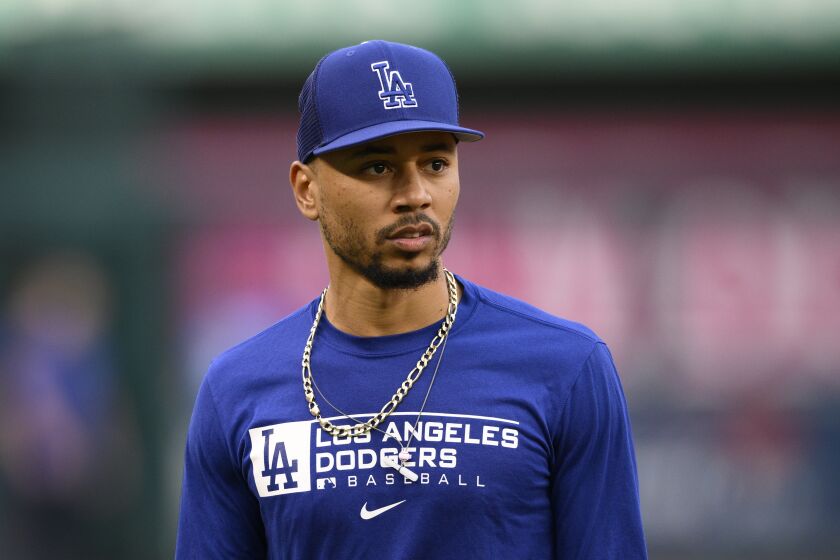 Los Angeles Dodgers' Mookie Betts looks on during batting practice before a baseball game.