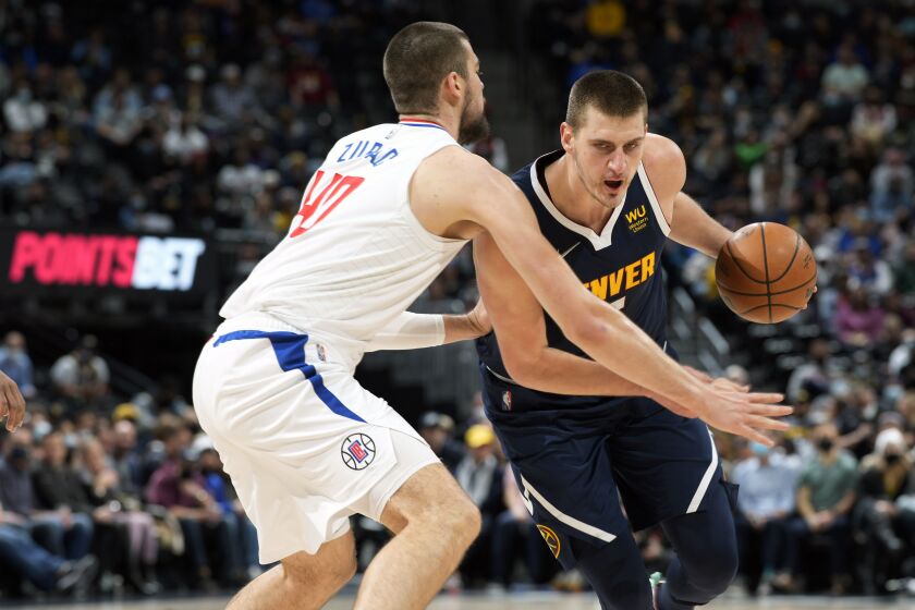 Denver Nuggets center Nikola Jokic, right, drives the lane as Los Angeles Clippers center Ivica Zubac.