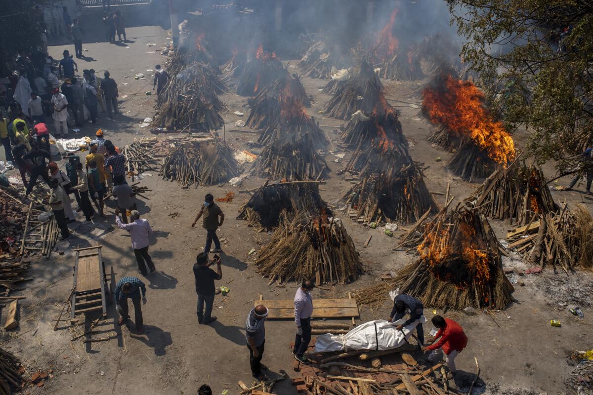Multiple funeral pyres of victims of COVID-19 burn in New Delhi. 