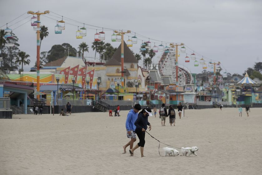 People visit a beach in front of the Santa Cruz Beach Boardwalk during the coronavirus outbreak in Santa Cruz, Calif., Thursday, July 2, 2020. (AP Photo/Jeff Chiu)