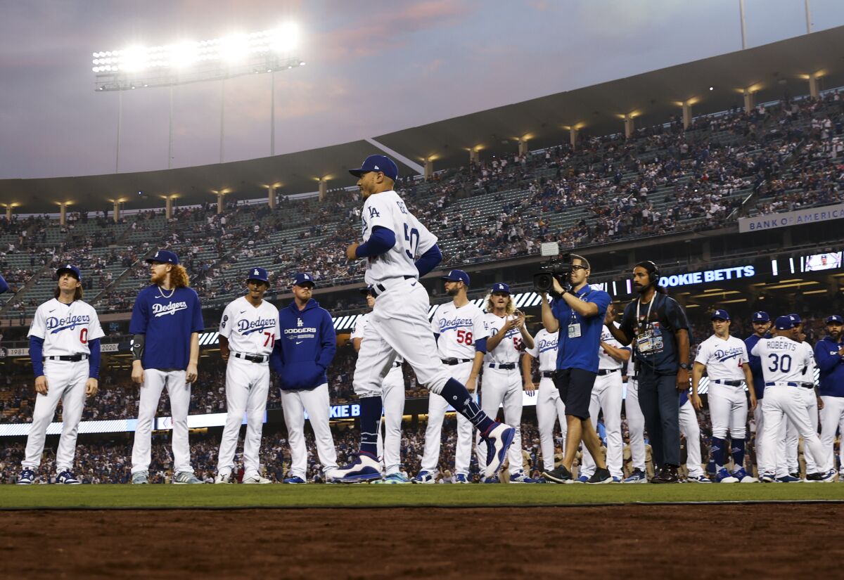 Dodgers right fielder Mookie Betts jogs past the rest of the team as he is introduced before game one of the NLDS