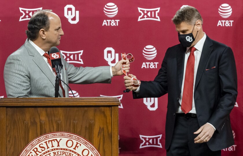 University of Oklahoma vice president and director of athletics Joe Castiglione hands over the coach's whistle to new men's basketball coach Porter Moser during his introductory press conference at Lloyd Noble Center in Norman, Okla., Wednesday, April 7, 2021. (Chris Landsberger/The Oklahoman via AP)