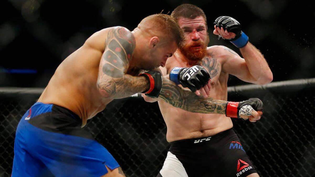 Dustin Poirier, left, and Jim Miller exchange punches during their lightweight bout at UFC 208.