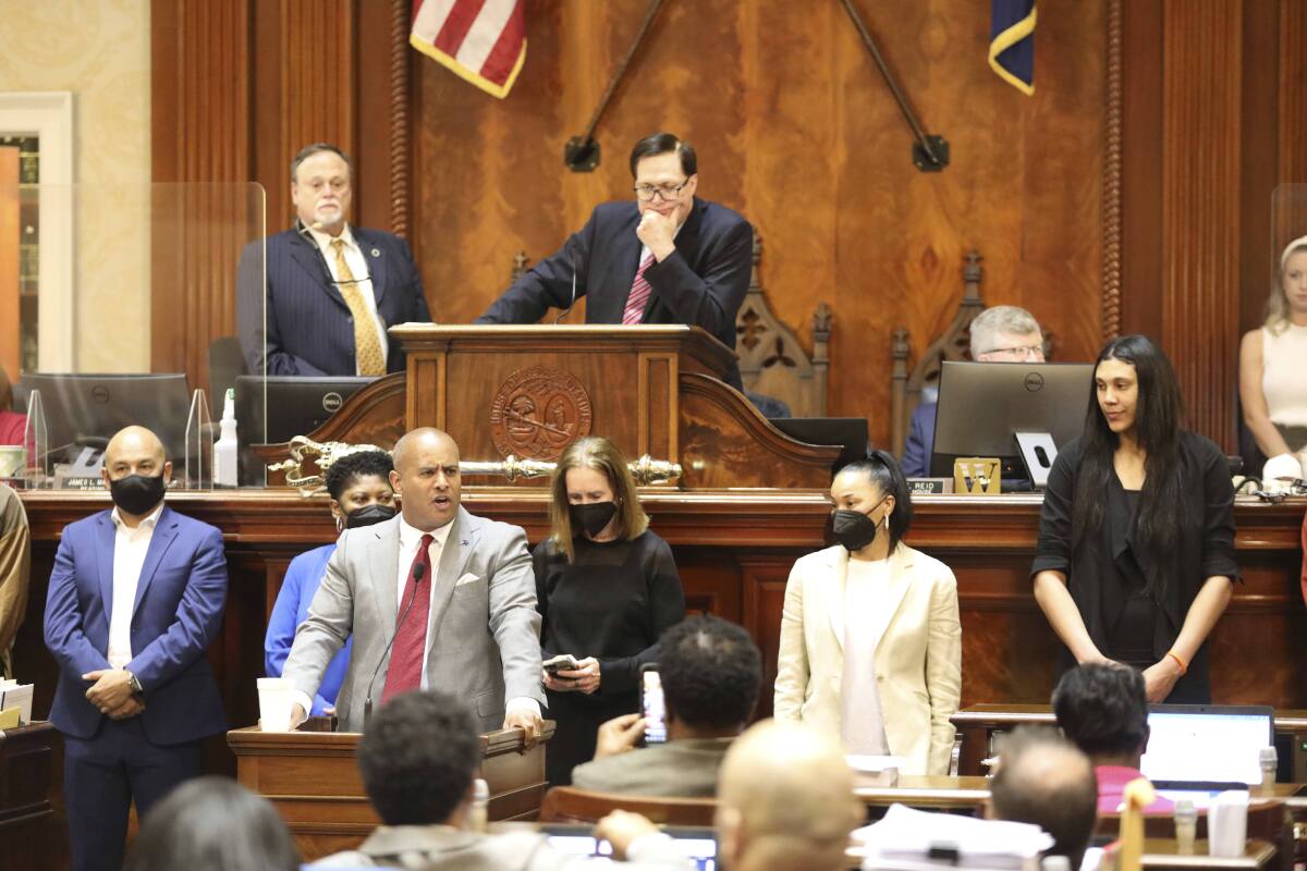 South Carolina women's basketball coach Dawn Staley, standing second from right wearing a mask, and her national championship team are honored by the South Carolina House on Wednesday, April, 6, 2022, in Columbia, South Carolina. (AP Photo/Jeffrey Collins)