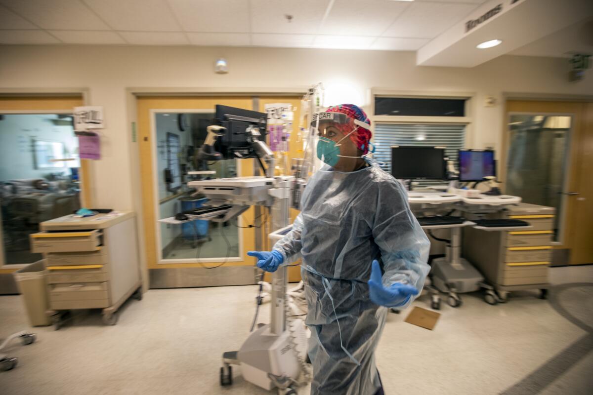 A doctor walks through a medical center in full protective gear.