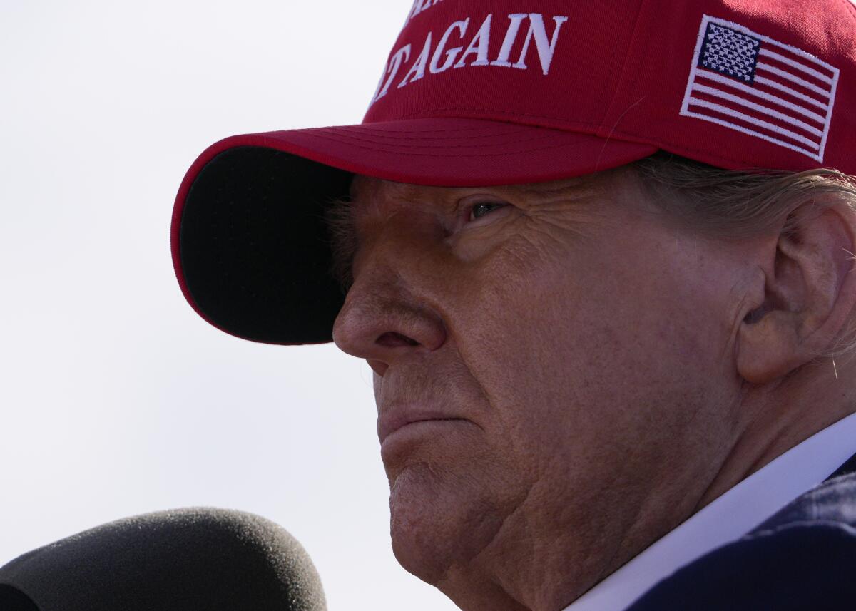 Donald Trump in a MAGA red hat at a campaign rally.