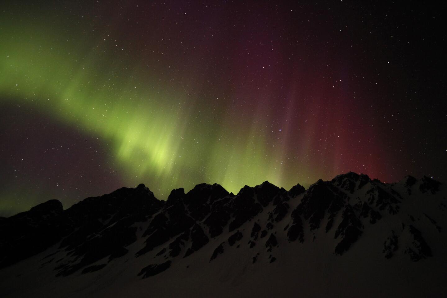 The aurora borealis is seen over campers in the snow in Chugach mountain range, outside the town of Valdez, east of Anchorage April 21, 2012.