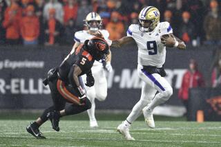 Washington quarterback Michael Penix Jr. sticks his arm out as he pushes past Oregon State's Easton Mascarenas-Arnold 