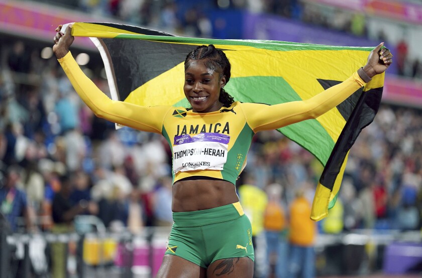 Jamaica's Elaine Thompson-Herah celebrates after winning the Women's 100m final, in the Alexander Stadium at the Commonwealth Games in Birmingham, England, Wednesday, Aug. 3, 2022. (Mike Egerton/PA via AP)