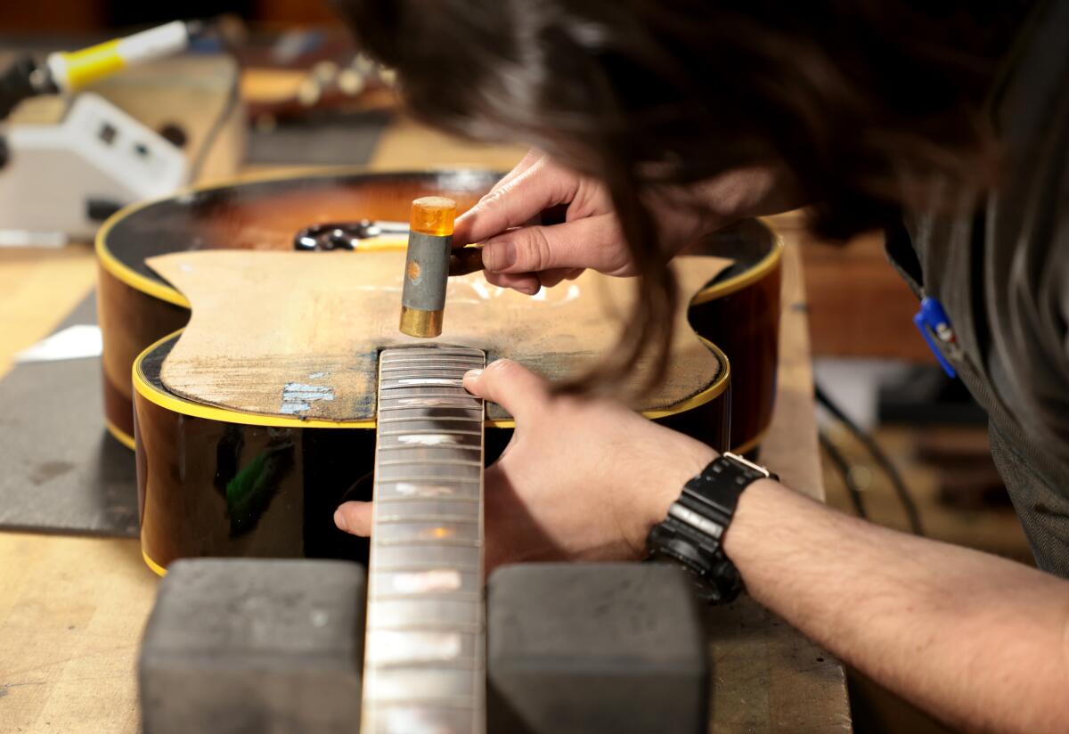 Ryan Schuermann works on a guitar at LA Guitar Repair.