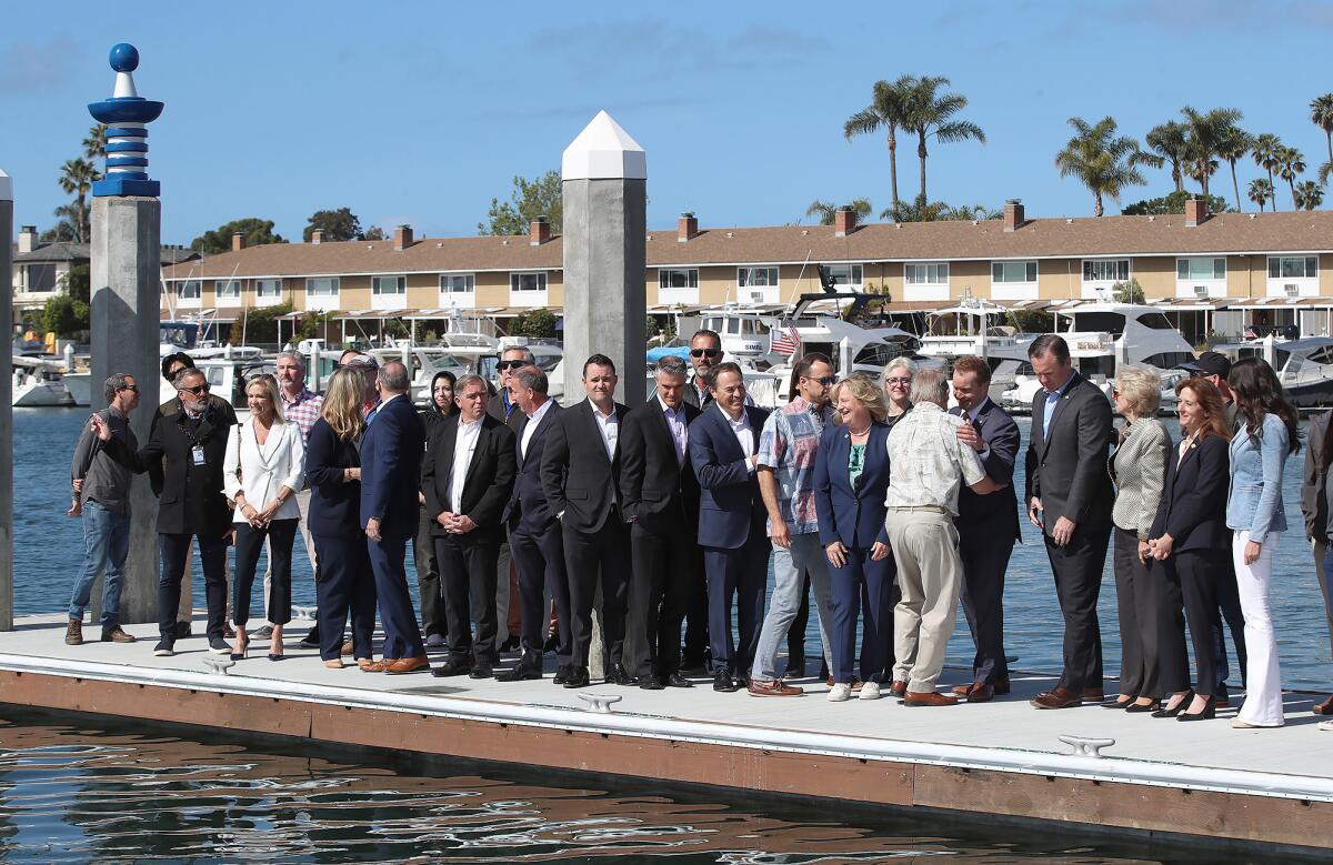 Representatives of Newport Beach, the county and the Irvine Co. on the dock of the Balboa Marina Public Pier.