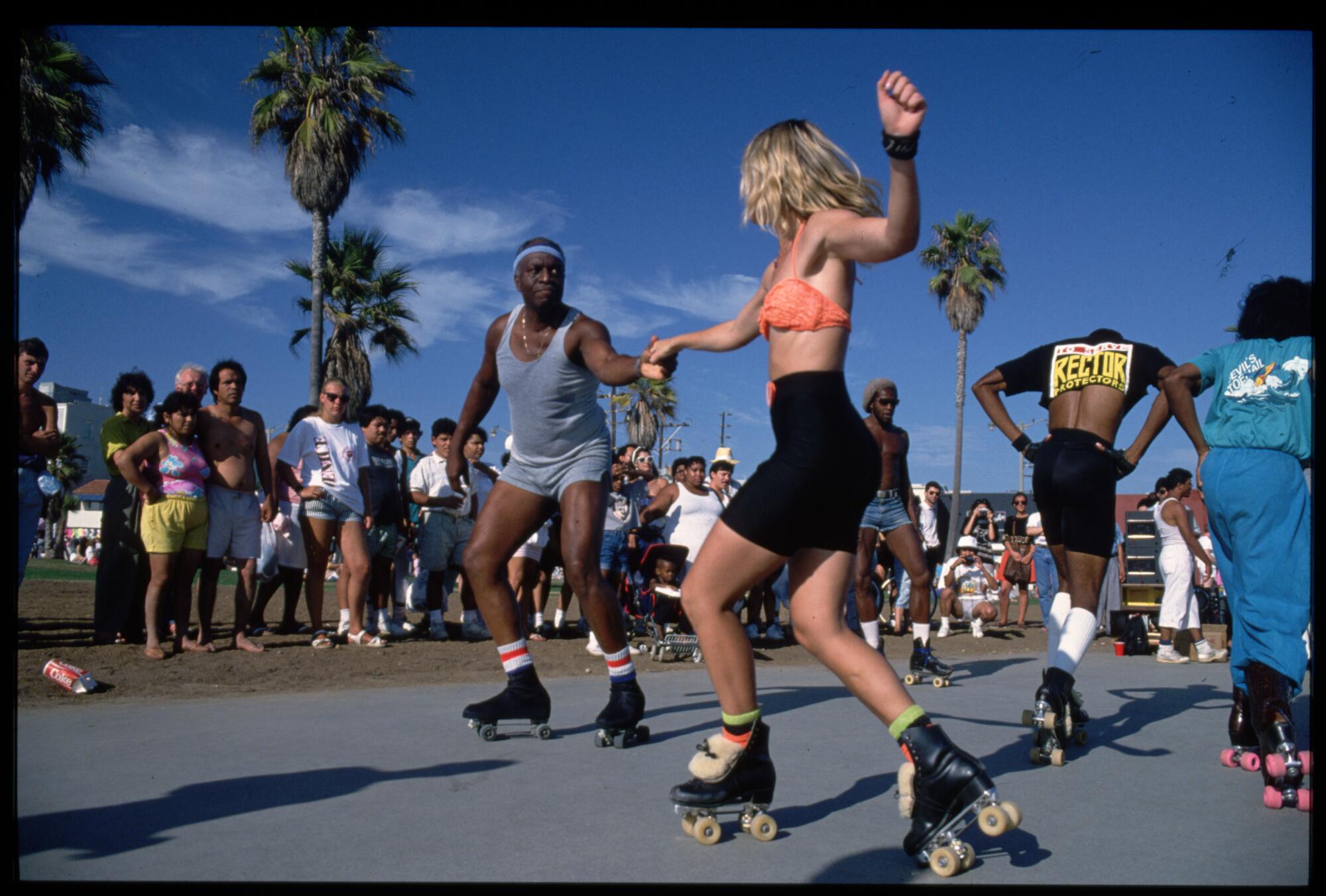 Roller skaters dance on the boardwalk at Venice Beach, Calif.