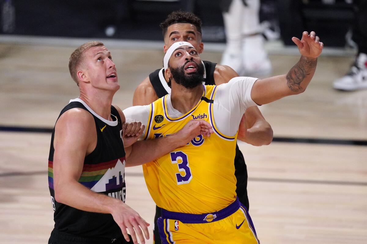 Nuggets power forward Mason Plumlee, left, and Lakers forward Anthony Davis battle for a rebound.