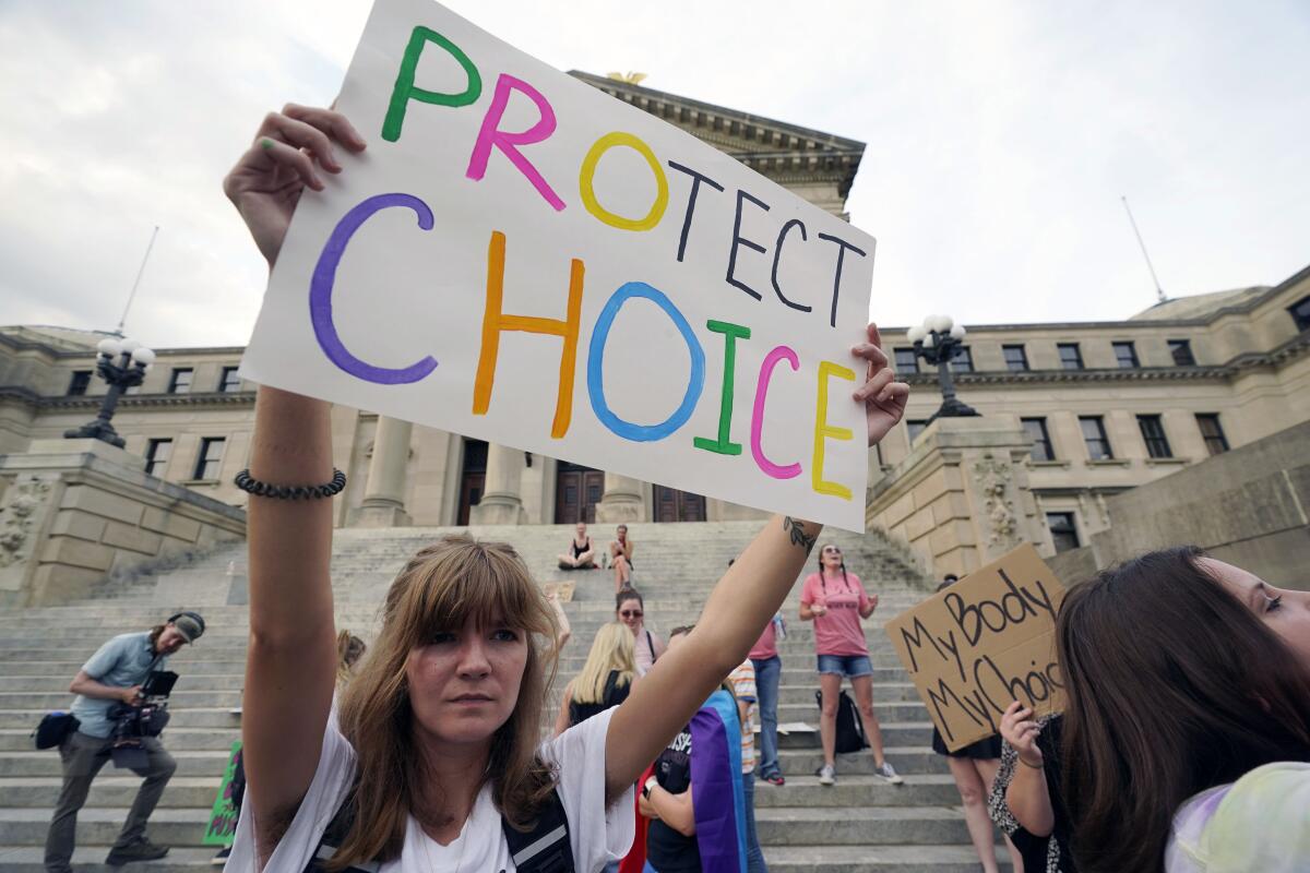 An abortion-rights supporter holds a 'Protect Choice' sign and protests at the Mississippi Capitol.
