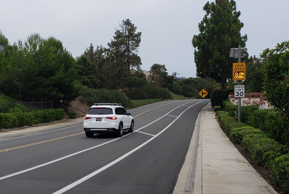 A flashing speed indicator sign on Cardeno Drive flashes "slow down" as a driver exceeds the speed limit.