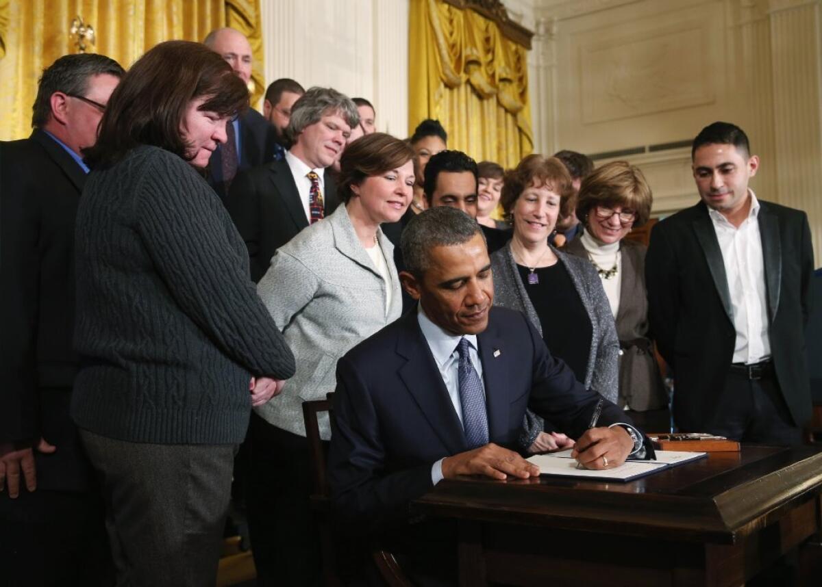 President Obama is seen at the White House on Thursday signing a memorandum directing the Department of Labor to construct a new set of rules to make more employees eligible for overtime pay.