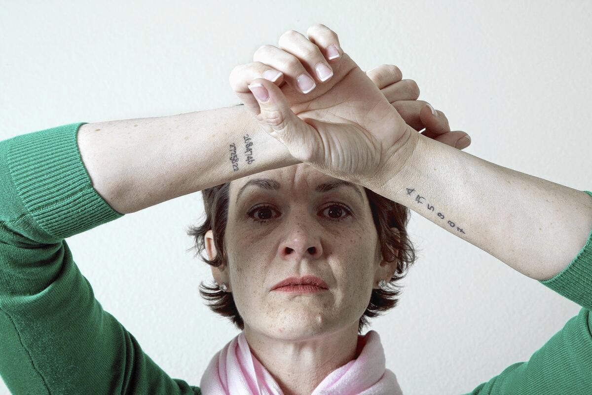 Jennifer Hoff of Ladera Ranch, whose mentally ill adult son is in prison for bank robbery, believes Laura's Law could have helped him and kept him out of prison. As in most of California, the law has not been implemented in Orange County. The tattoos on Jennifer's arms are her son's booking numbers from various arrests.