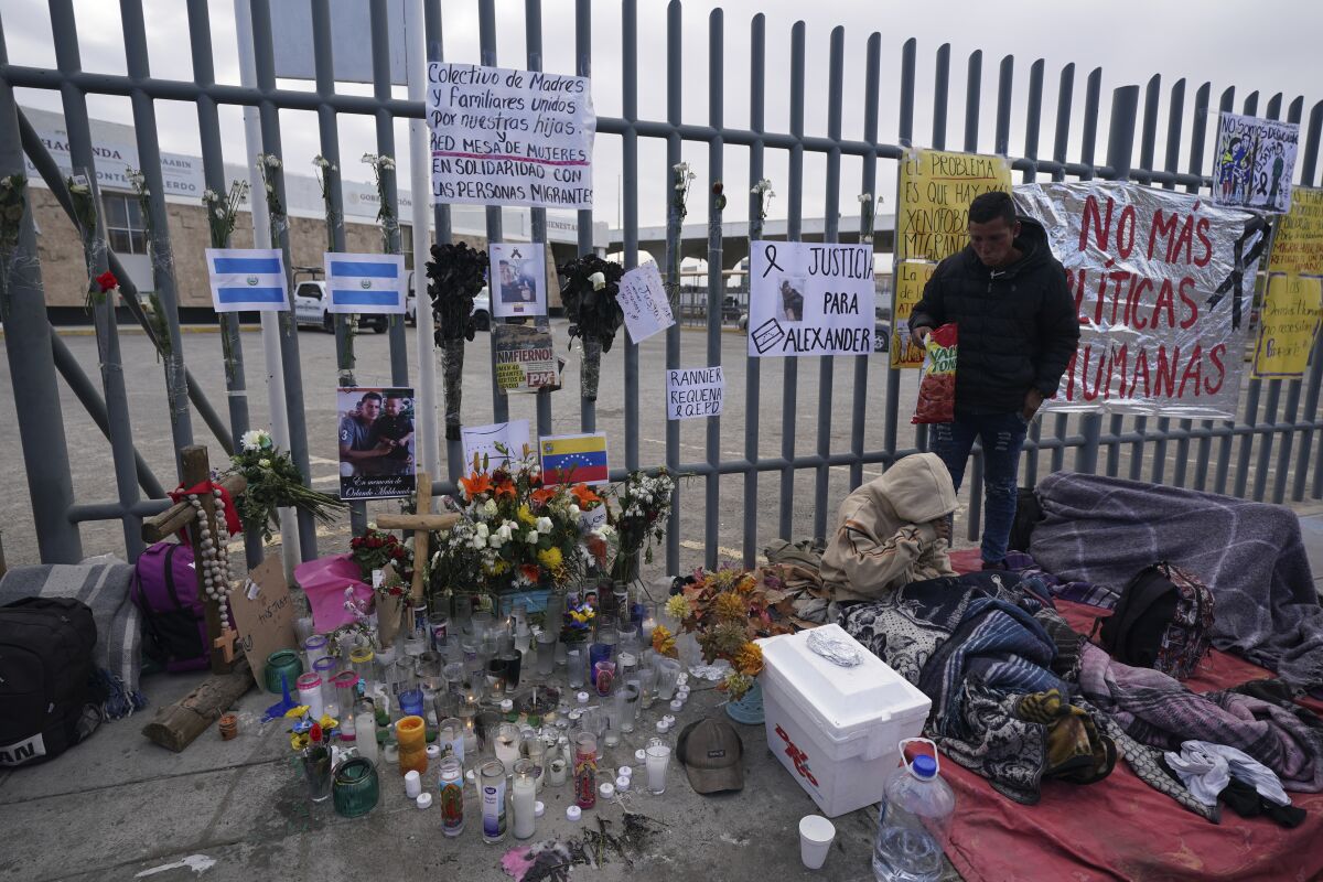 Un altar con velas y fotos cubre la cerca afuera del centro de detención de migrantes.