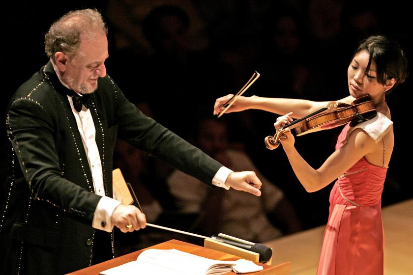 Gallardo, Alex   Violin soloist Sayako Kusaka, right, plays for conductor Eduard Schmieder and with I Palpiti Orchestra, a group of young international musicians formed a new every year by Eduard and Laura Schmieder performing Antonio Vivaldi, Le Quartro Stagoni (The Four Seasons) at Disney Hall Thursday, July 26, 2007.