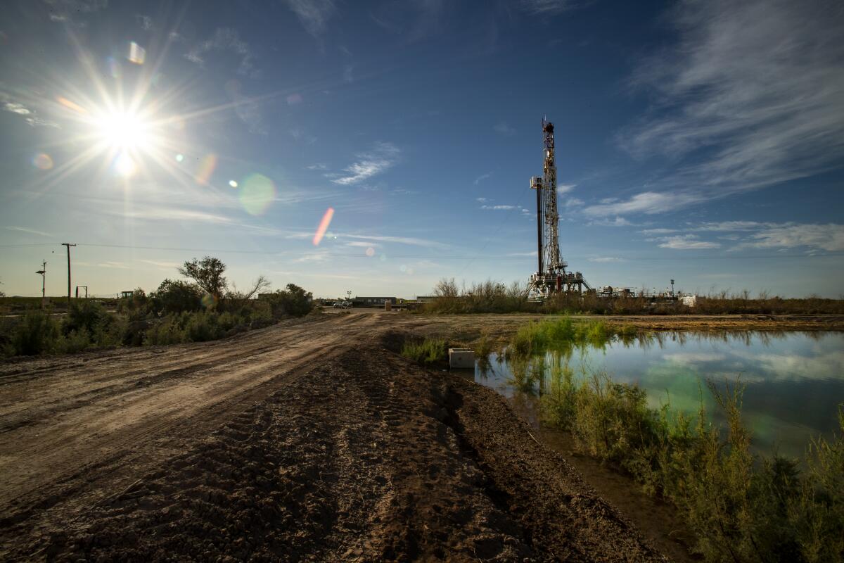 A pool of water is near a drill rig.