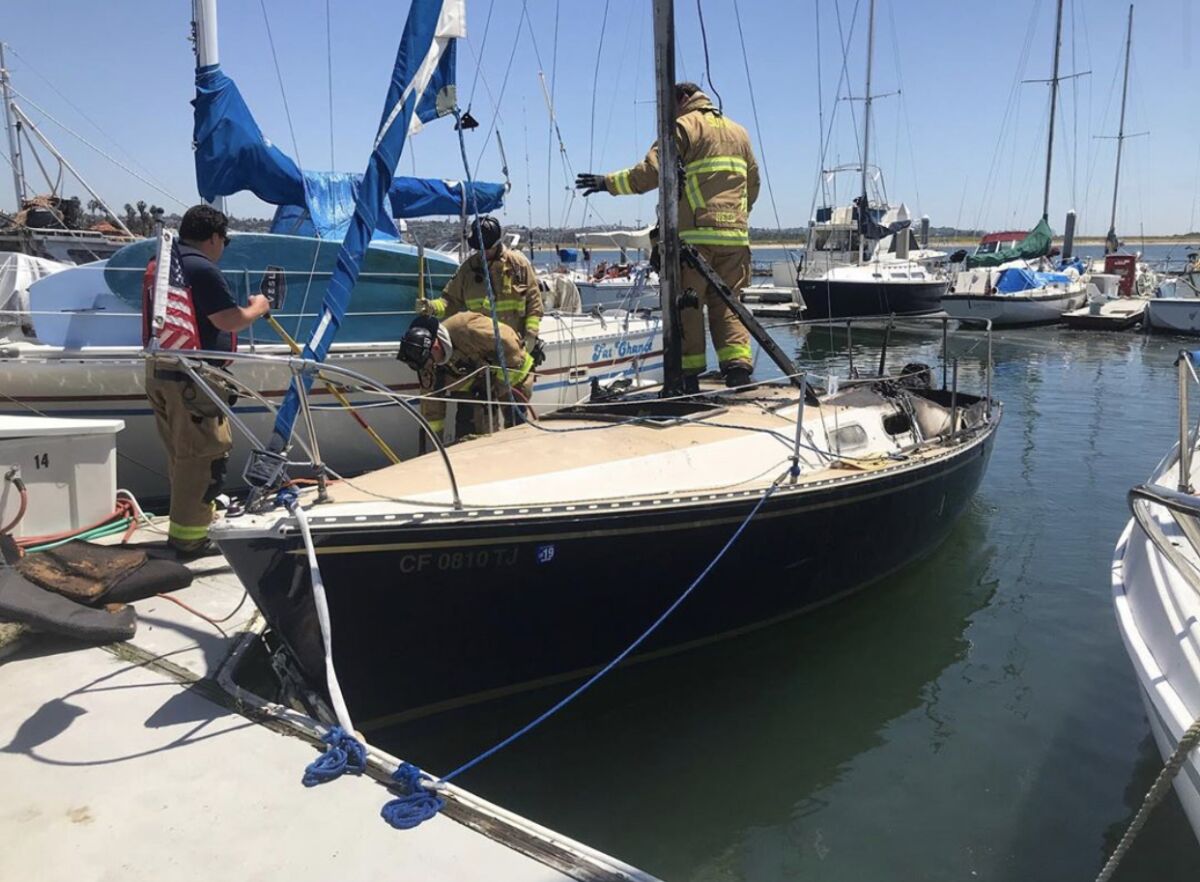 San Diego Fire-Rescue crews inspect a 22-foot boat after it caught fire Wednesday afternoon.