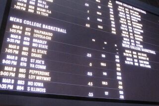 A betting board lists the odds on college basketball games in the sports betting facility at the Tropicana casino.