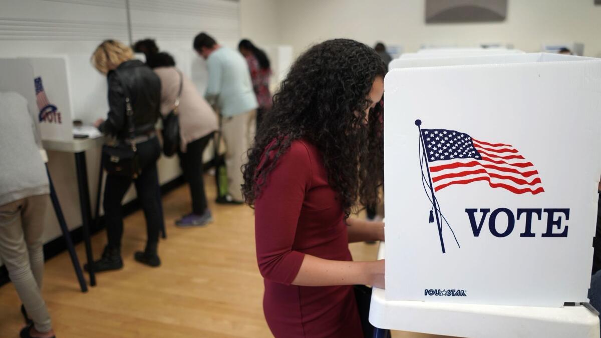 A woman marks her ballot at an early voting polling station at West Los Angeles College in Culver City on Sunday.
