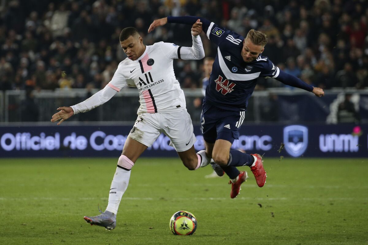 FILE - PSG's Kylian Mbappe, left, dribble Bordeaux's Stian Gregersen during the soccer League One match Bordeaux against Paris Saint-Germain at the Matmut Atlantique stadium in Bordeaux, southwestern France, Saturday, Nov. 6, 2021. Heading for record losses and facing the prospect of relegation to the second division, Bordeaux is in survival mode. (AP Photo/Bob Edme, File)