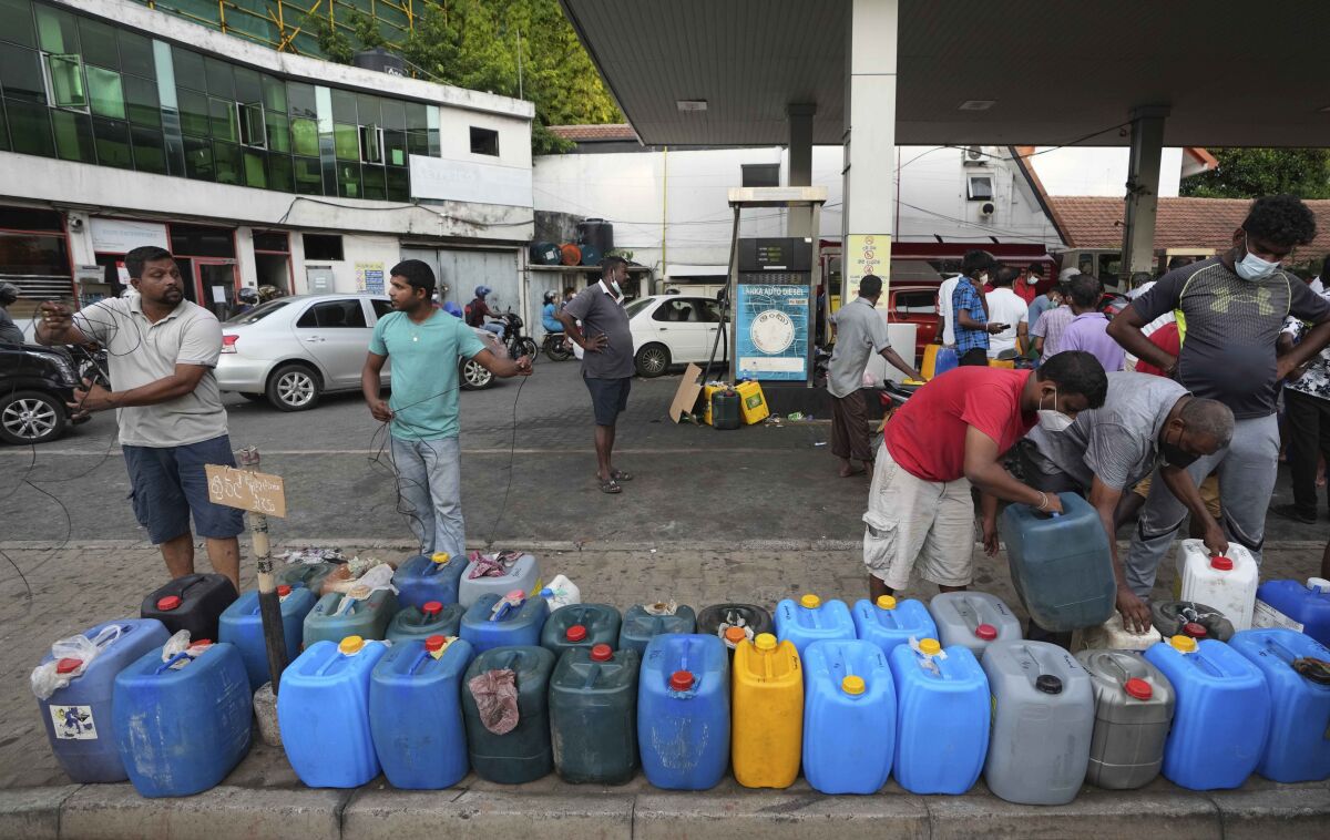 Sri Lankans gather at a fuel station to buy diesel before the beginning of curfew in Colombo, Sri Lanka, Saturday, April 2, 2022. Sri Lanka imposed a countrywide curfew starting Saturday evening until Monday morning, in addition to a state of emergency declared by the president, in an attempt to prevent more unrest after protesters took to the streets blaming the government for the worsening economic crisis. (AP Photo/Eranga Jayawardena)