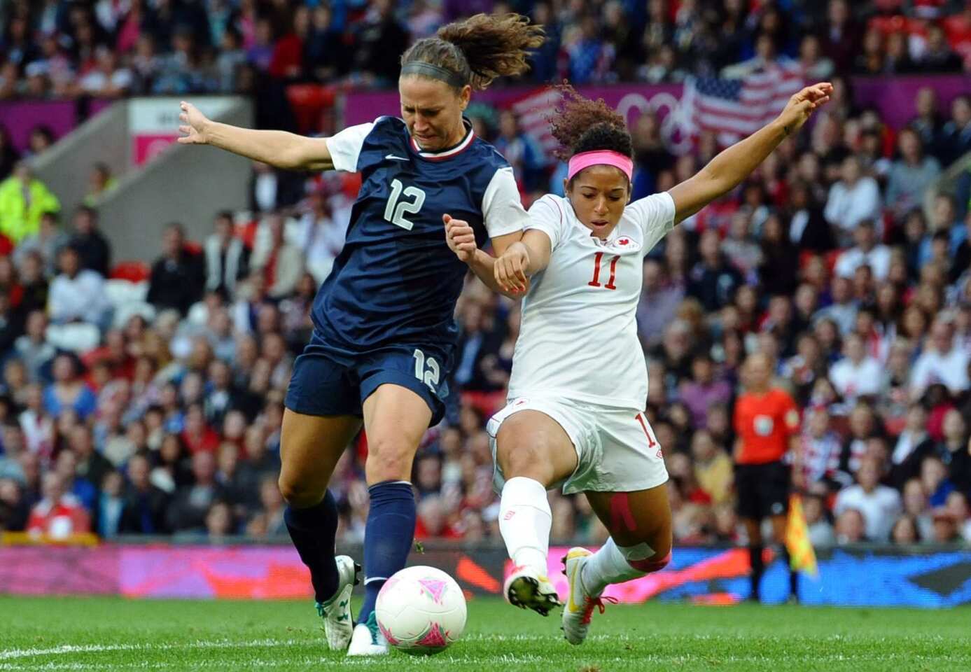 U.S. forward Lauren Cheney, left, is tackled by Canadian midfielder Desiree Scott.