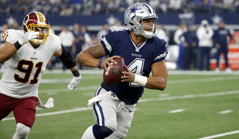 Dallas Cowboys quarterback Dak Prescott evades pressure from Washington Redskins linebacker Ryan Kerrigan during a game on Nov. 24.