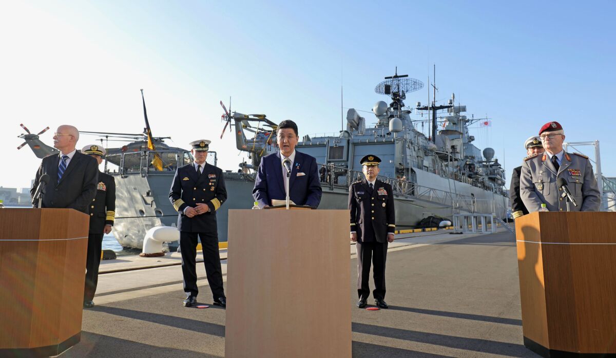 Japan’s Defense Minister Nobuo Kishi, center, speaks as Gen. Eberhard Zorn, right, chief of Defense of the German Armed Forces, listens during a news conference in front of the German navy frigate Bayern at Tokyo International Cruise Terminal in Tokyo, Friday, Nov. 5, 2021. Kishi on Friday said Japan will step up military cooperation with Germany in the Indo-Pacific region as he welcomed a port call by the first German warship to visit Japan in about 20 years. (Kyodo News/Japan Pool Photo via AP)