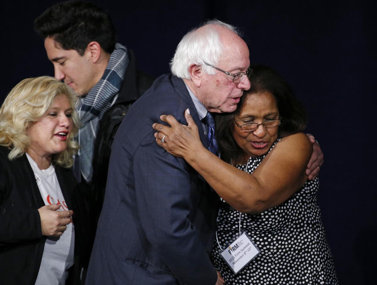 Democratic presidential candidate Sen. Bernie Sanders, I-Vt., second from right, embraces Pricilia Rodriguez-Trillo at the Fair Immigration Reform Movement presidential candidate forum, Monday, Nov. 9, 2015, in Las Vegas. Sanders took questions on issues, including immigration reform and jobs, from participants on stage. (AP Photo/John Locher)