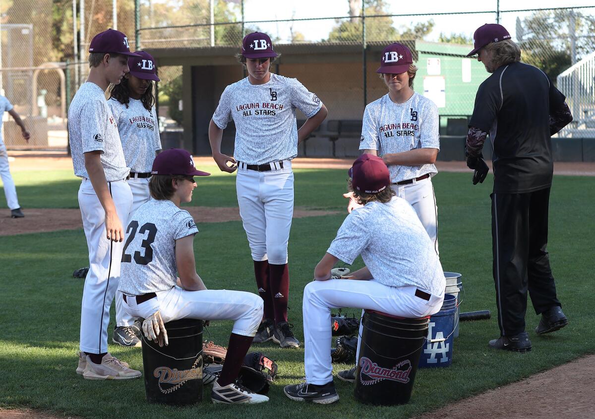 Players gather before drills during Laguna Beach Little League Intermediate All-Stars practice at Riddle Field on Tuesday.